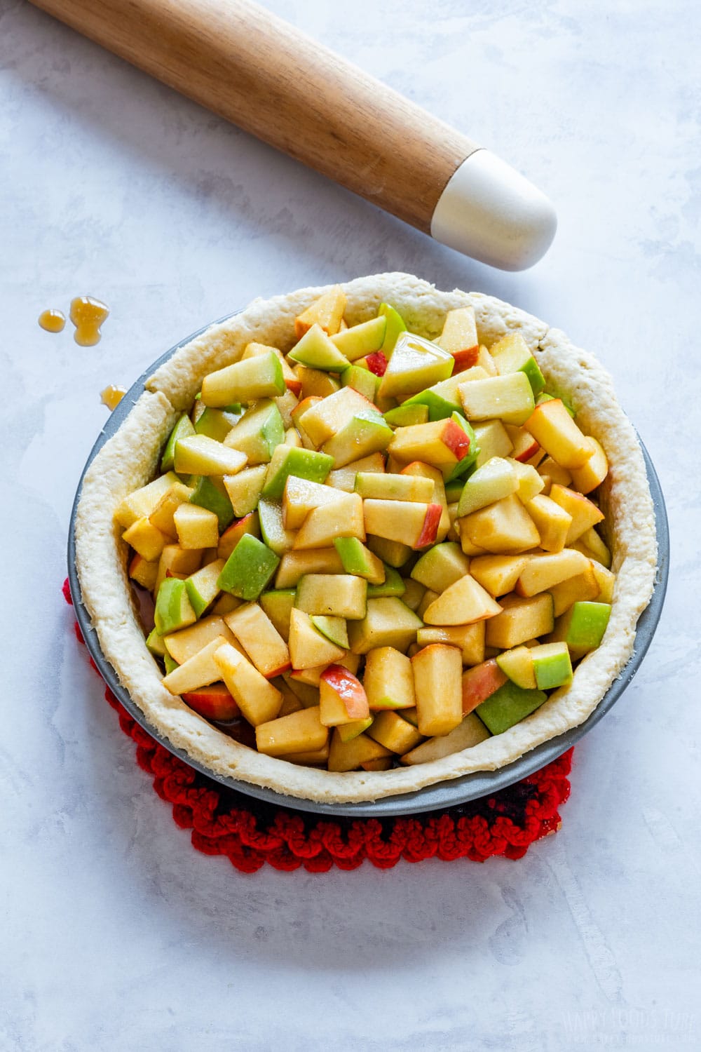 Uncooked apple pie filled with apple mixture.