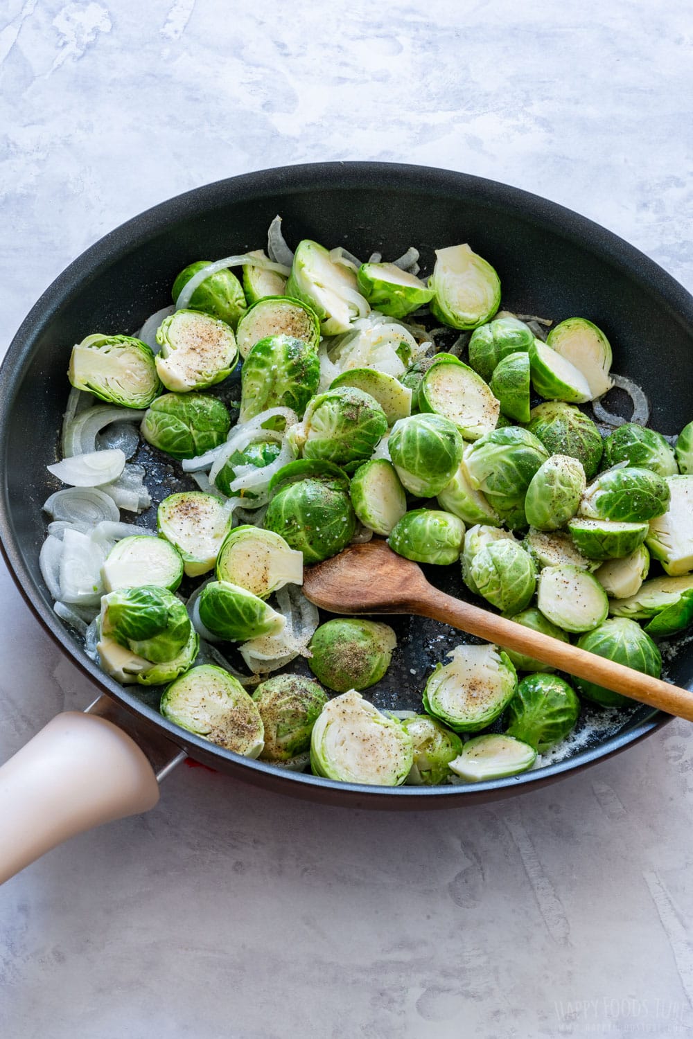Cooking Brussels sprouts and onions on the skillet.