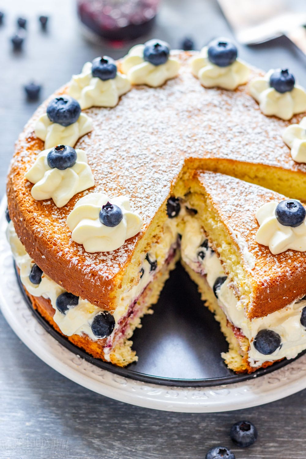 Homemade blueberry sponge cake with cream and fresh blue berries.