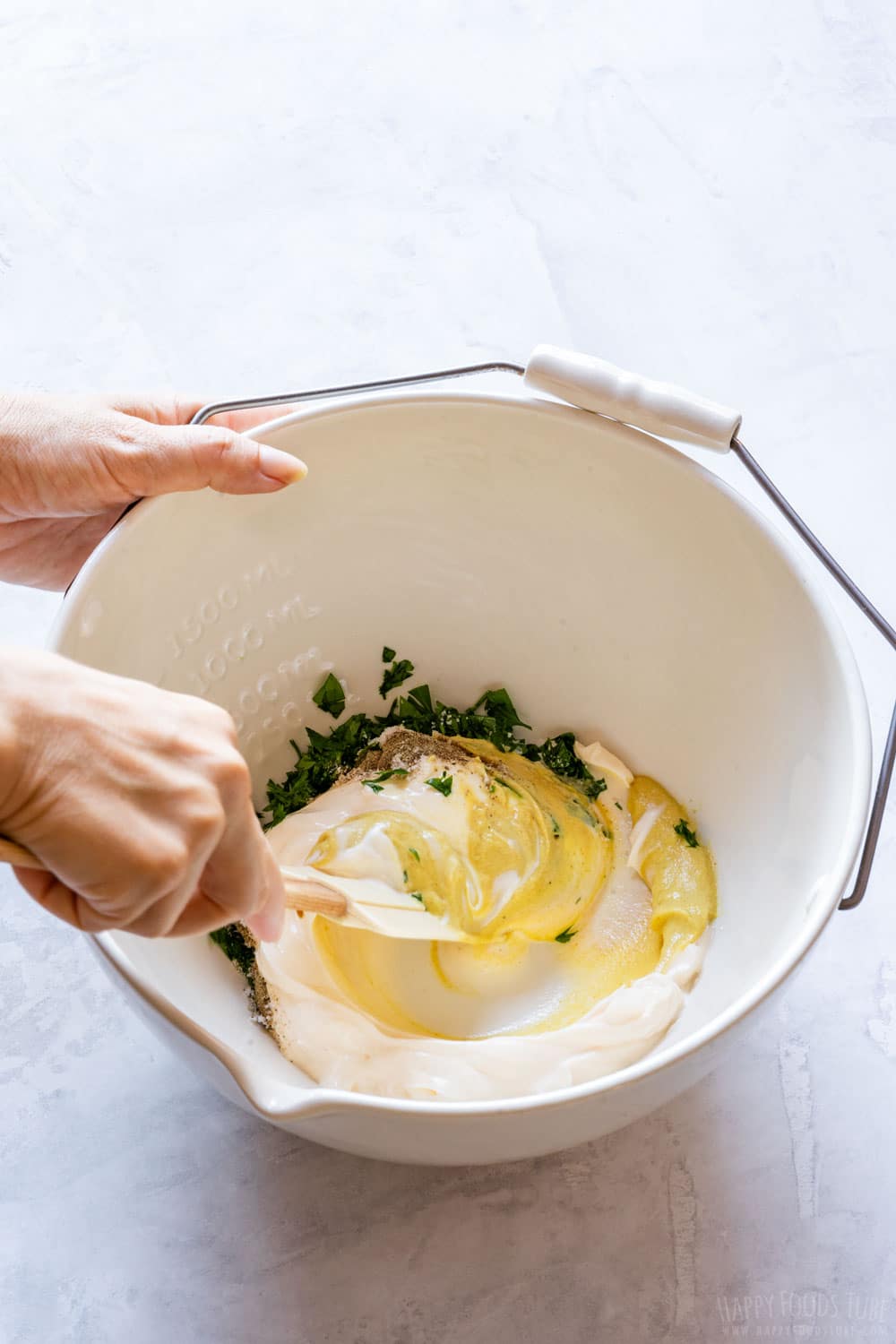 Combining mayonnaise, mustard, salt, black pepper, sugar and parsley in a large mixing bowl.
