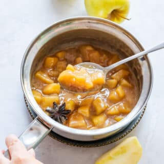 Lifting spoon with delicious apple pie filling.
