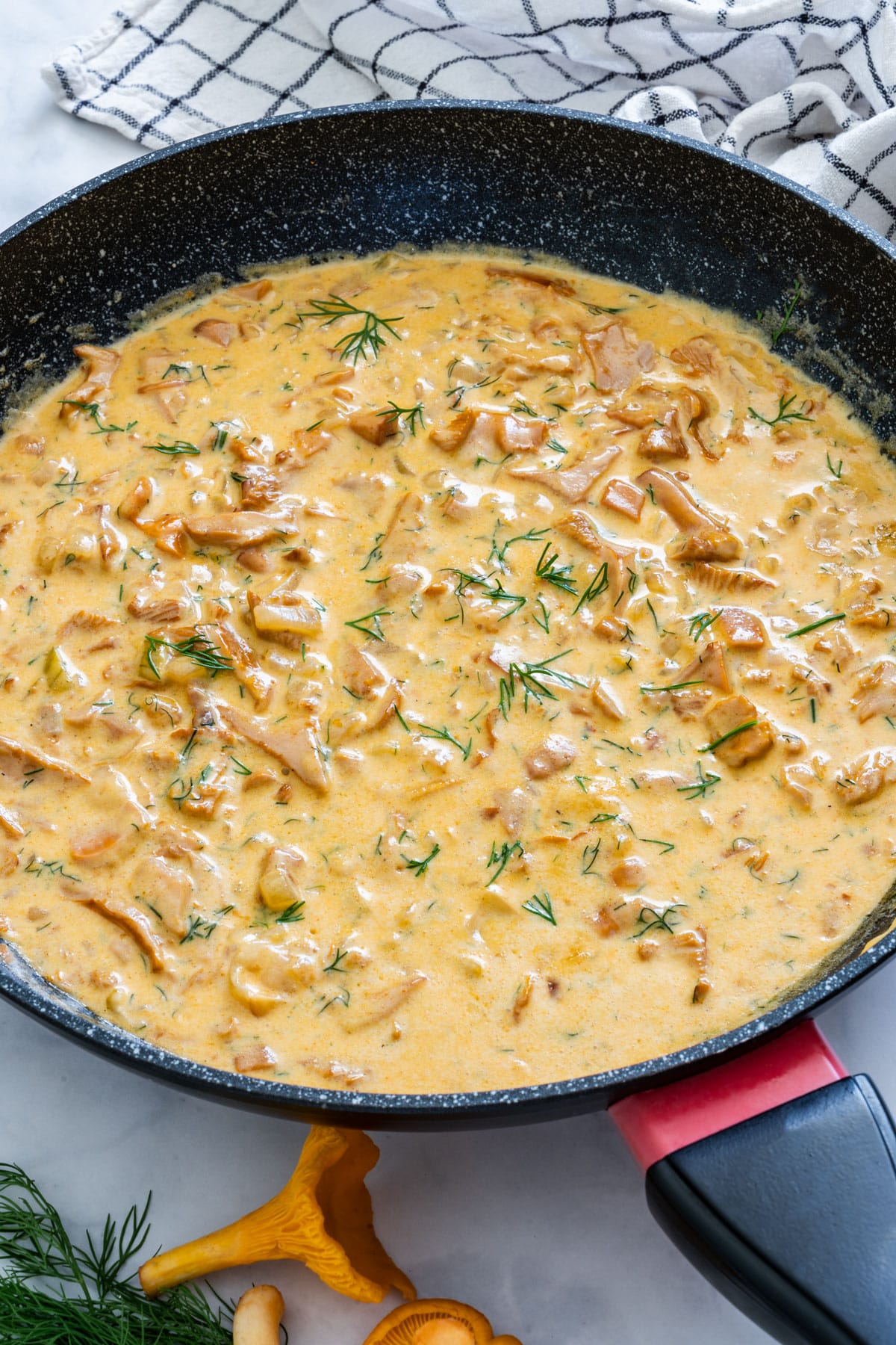 Cooking Chanterelle sauce on a pan with cream and dill.