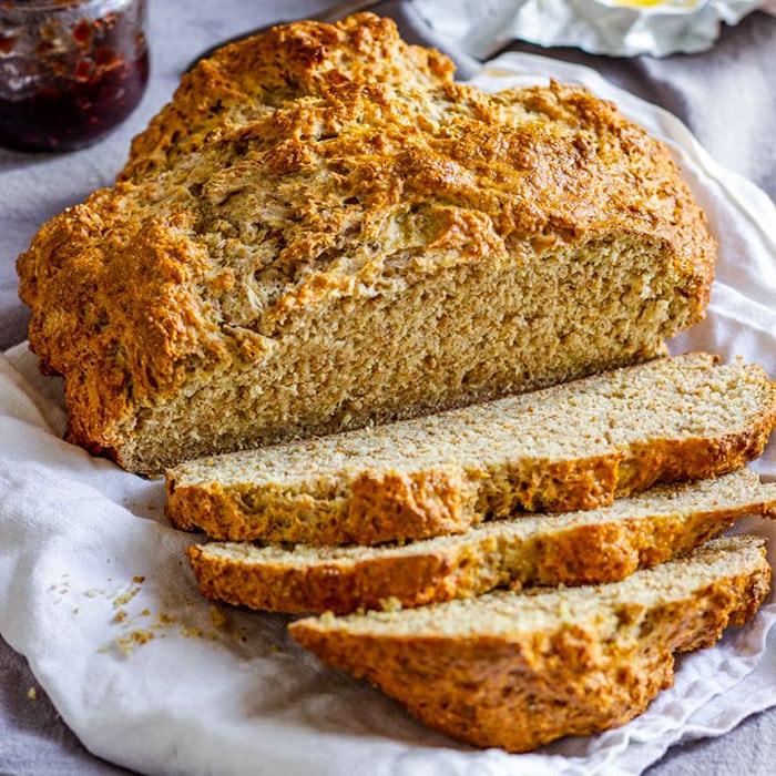 Sliced brown soda bread with a rustic brown crust.