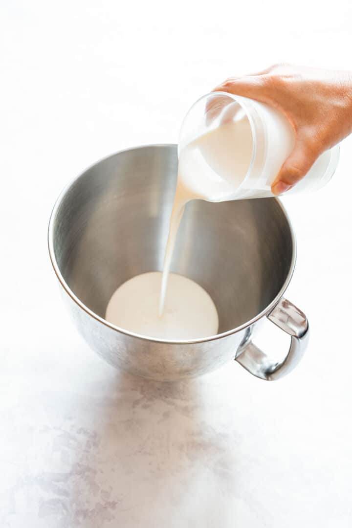 Pouring heavy cream into a stand mixer bowl to start making butter.