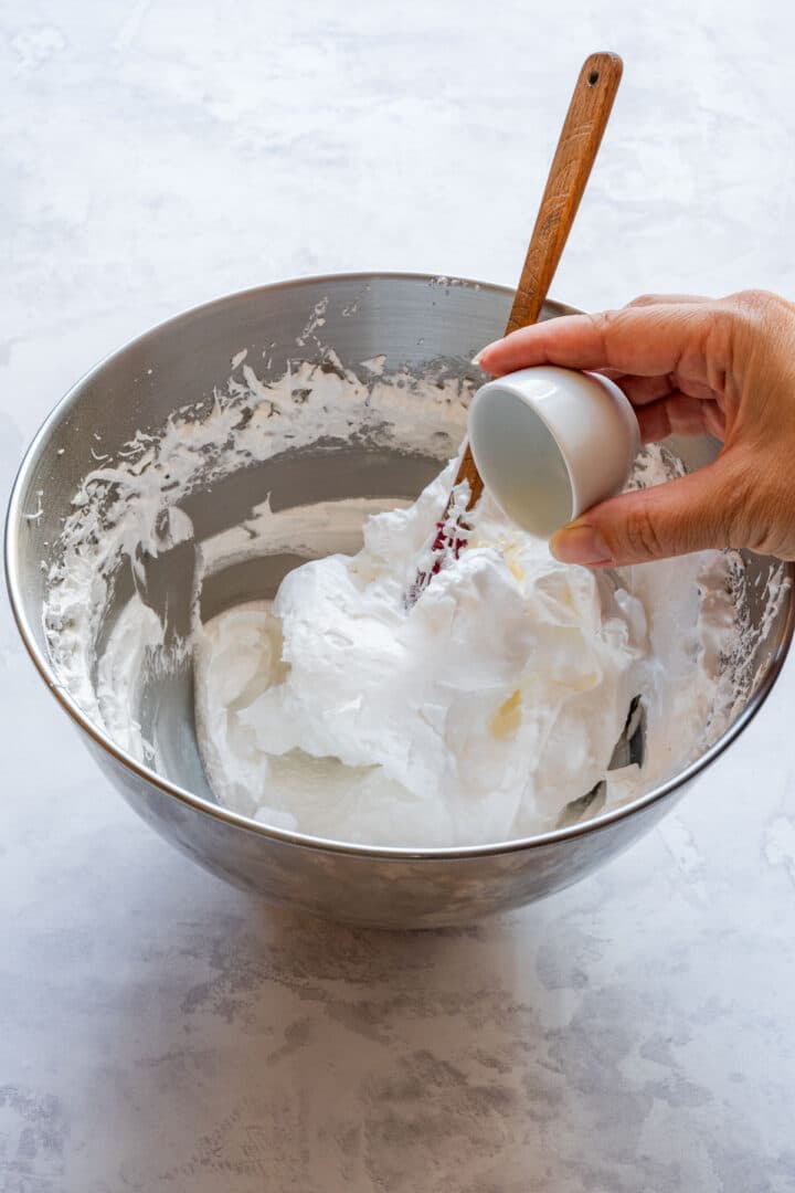 Adding a small splash of vinegar to the whipped meringue.