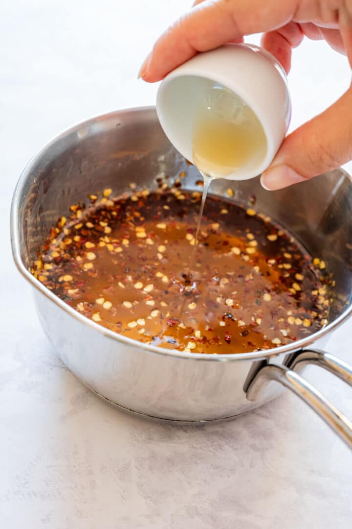 Adding apple cider vinegar to the honey and chili mixture.
