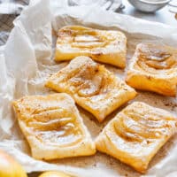 Golden baked pear tarts with flaky puff pastry and a light dusting of powdered sugar.