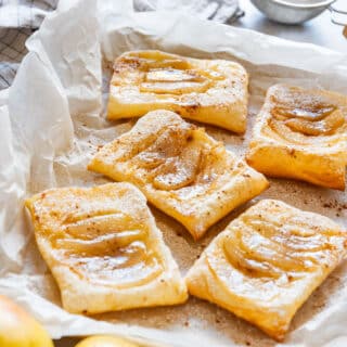 Golden baked pear tarts with flaky puff pastry and a light dusting of powdered sugar.