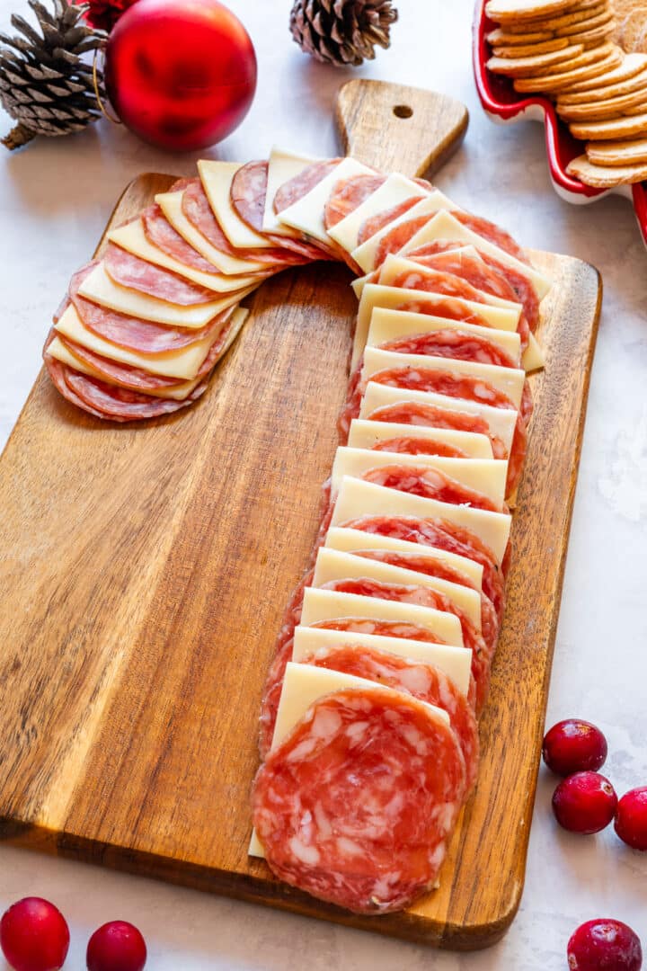Close up of finished salami and cheese candy cane appetizer with crackers nearby.