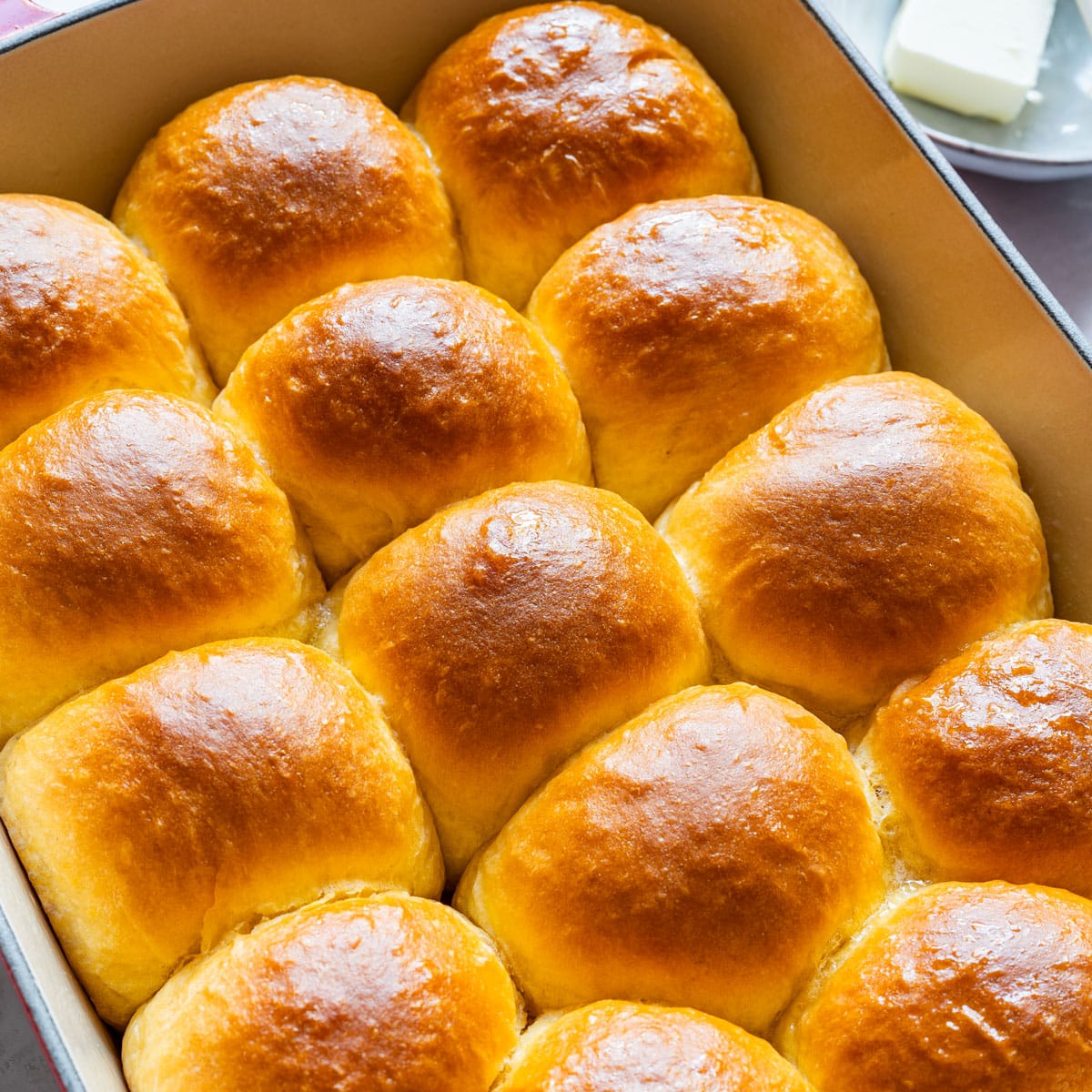 Freshly baked sweet potato dinner rolls with golden, buttery tops.