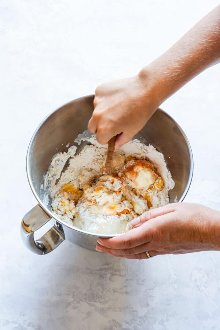 Mixing mashed sweet potato, egg, milk and butter into the dry ingredients.