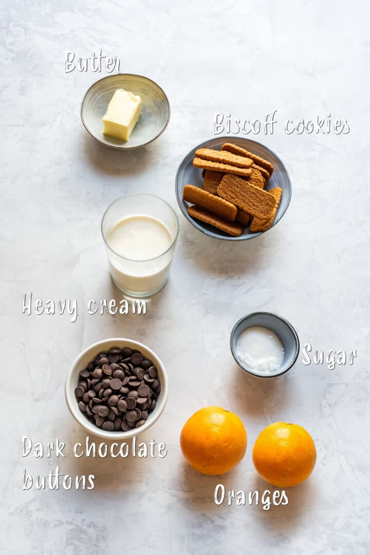 Ingredients for chocolate orange tart: Biscoff cookies, heavy cream, dark chocolate, butter, sugar and oranges.