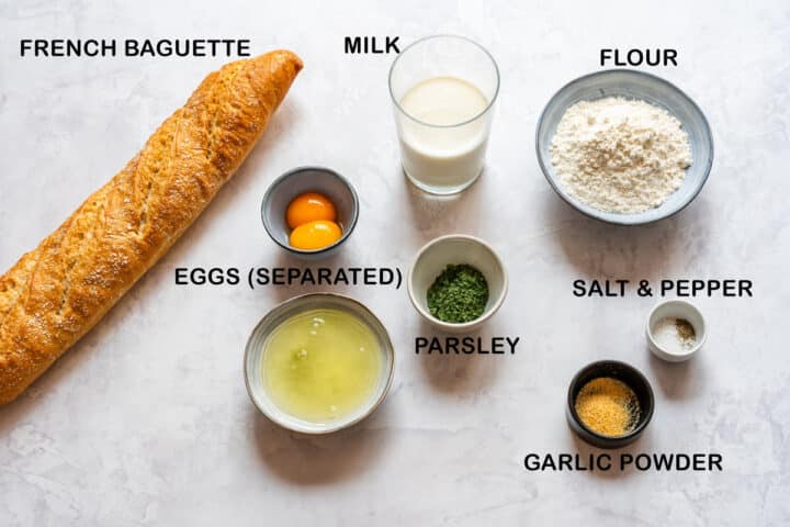 Ingredients for Czech Carlsbad dumplings including baguette, eggs, milk, flour, parsley and seasonings.
