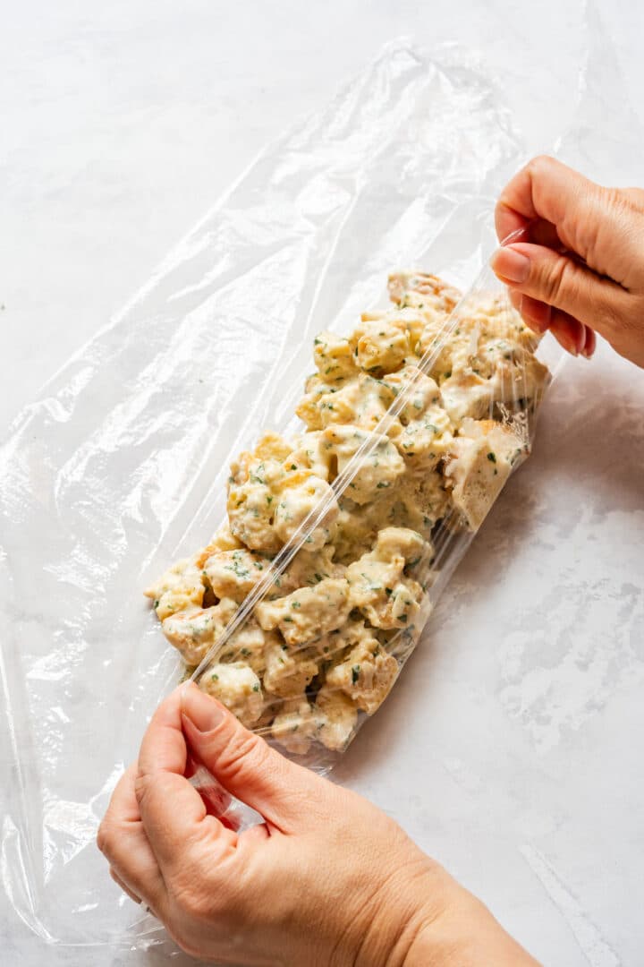 Bread dumpling mixture wrapped tightly in plastic wrap before cooking.