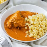 Chicken paprikash in a white bowl with pasta shells and creamy paprika sauce.