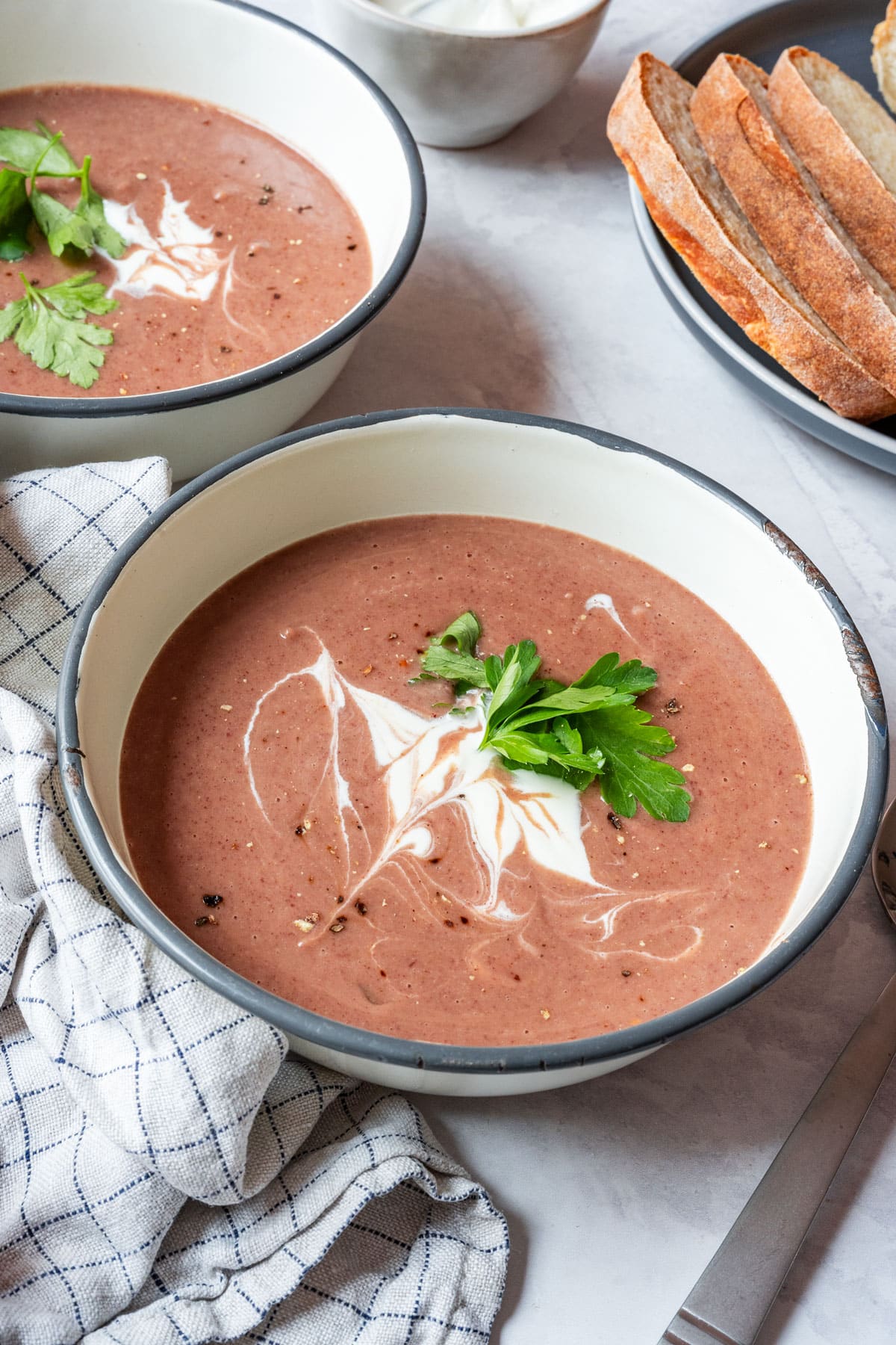 Creamy red bean soup topped with sour cream and parsley, served with crusty bread.