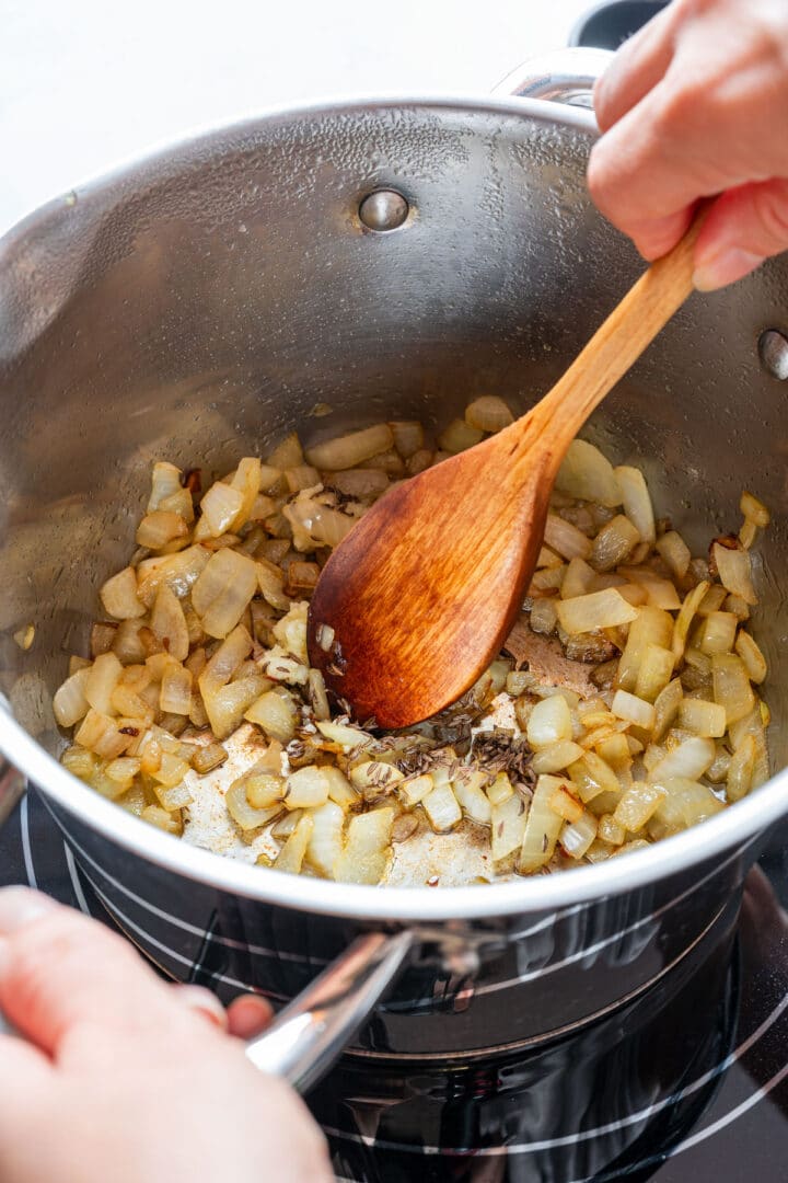 Sautéed onion, garlic and caraway seeds cooking in a pot.