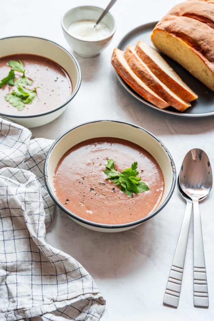 Smooth red bean soup served in bowls with bread on the side.