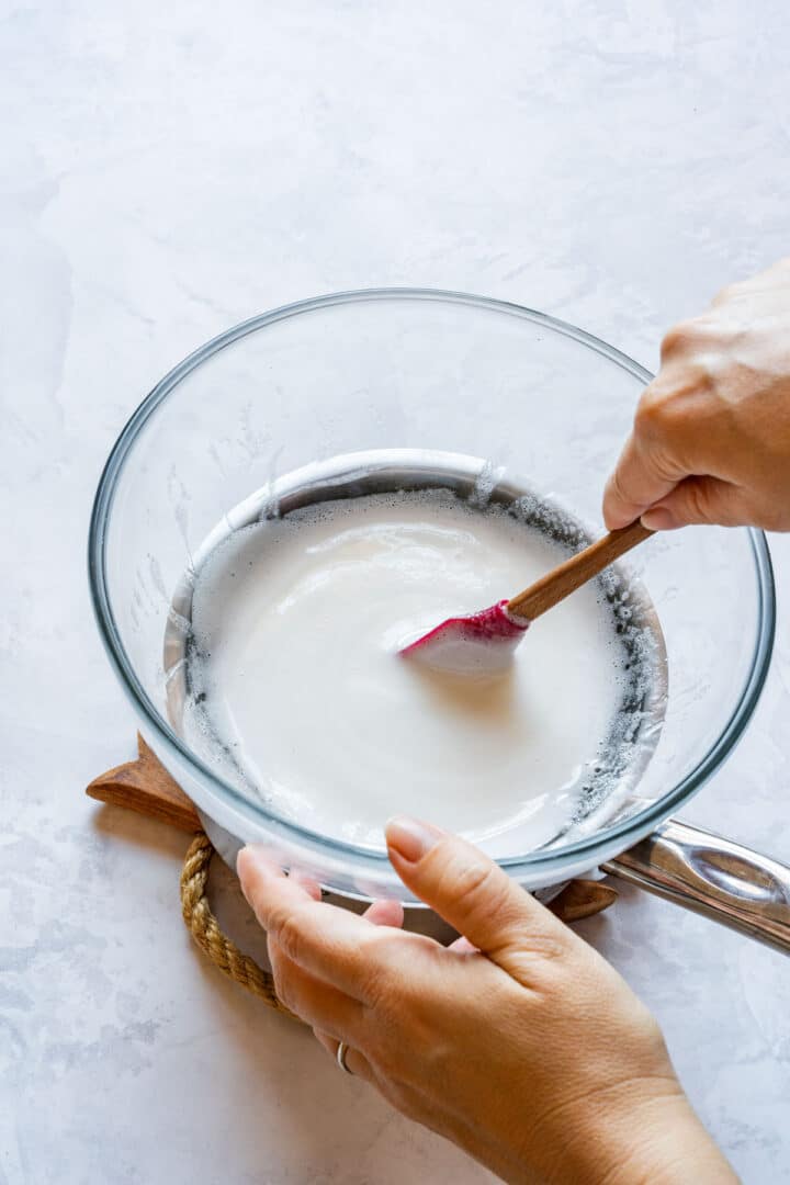 Stirring warmed egg whites and sugar until smooth for Swiss meringue.
