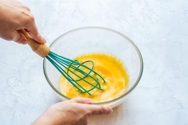 Whisking the lemon mixture in a glass bowl.