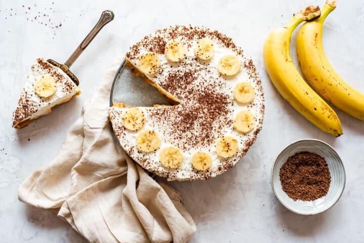 No-bake banoffee pie with one slice served, topped with banana slices and grated chocolate.