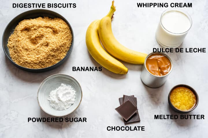 Ingredients for the pie with digestive biscuits, bananas, dulce de leche, whipping cream, powdered sugar, melted butter and chocolate.