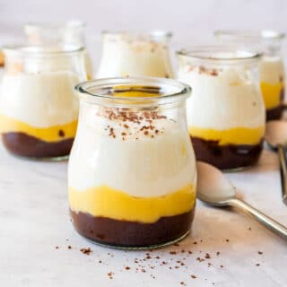 Lemon curd dessert cup with dulce de leche and whipped cream in a small glass.