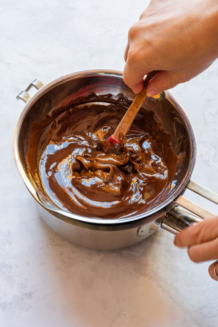 Stirring dulce de leche into melted chocolate for the base layer.