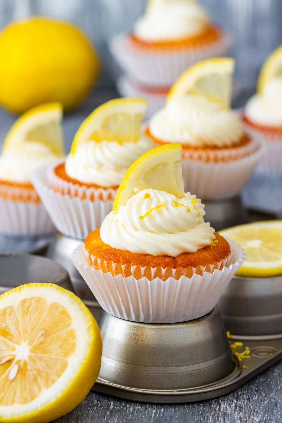 Easy lemon cupcakes with mascarpone frosting topped with lemon slices and zest.