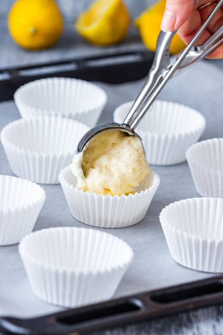 Filling cupcake liners with batter using a cookie scoop.