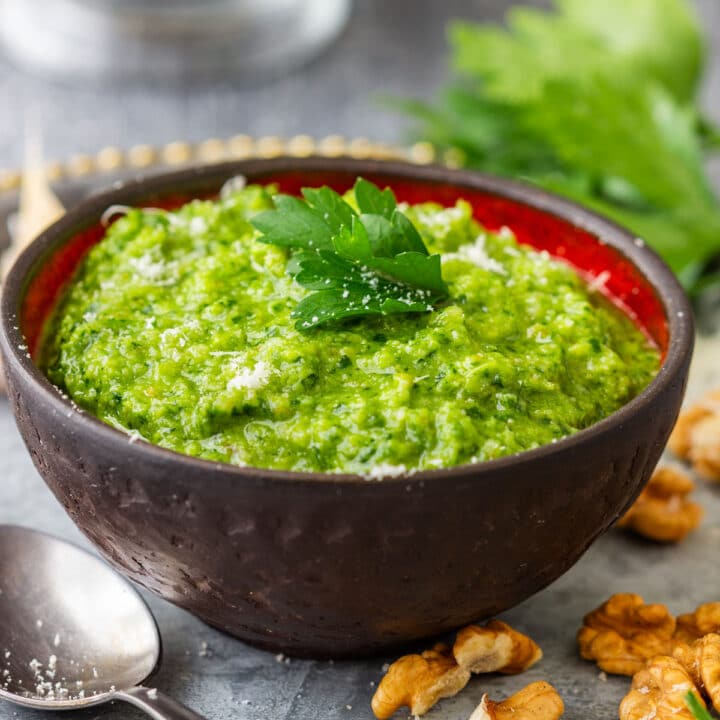 Homemade parsley pesto in a bowl with walnuts, garlic and fresh parsley.