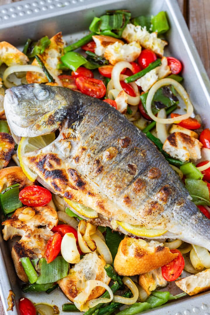 Learn how to grill a whole fish so the skin turns crisp and the fish stays tender and flaky. I serve it with a warm Italian bread salad made with grilled tomatoes, peppers, onion and grilled bread. A simple grilled sea bream recipe to save for BBQ season.