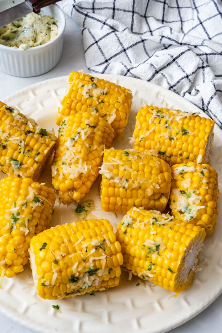 Garlic Parmesan corn on the cob made with a garlic, Parmesan, cilantro and lime butter you can prepare up to 3 days ahead. An easy summer side dish for cookouts.