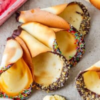 Oven-baked ice cream cones with chocolate-dipped rims, chopped nuts and colorful sprinkles.