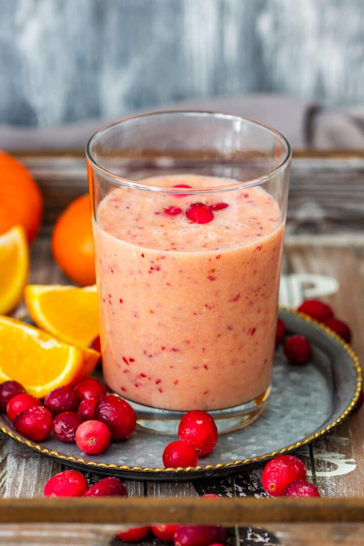 Orange cranberry smoothie recipe made with fresh oranges, frozen cranberries, banana, almond milk and maple syrup. This tart and fruity winter smoothie is naturally vegan, gluten-free and ready in about 5 minutes.