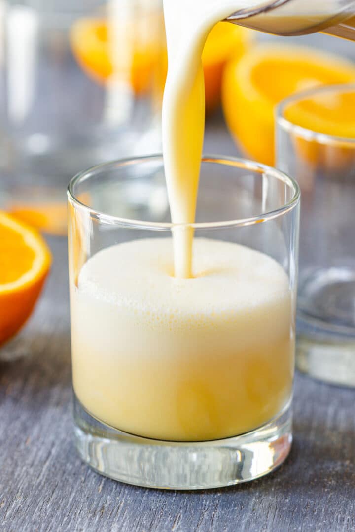 Homemade Orange Julius recipe made with fresh oranges and no frozen concentrate. Freshly squeezed orange juice is blended with milk, ice, maple syrup and optional vanilla until cold and frothy in about 10 minutes.