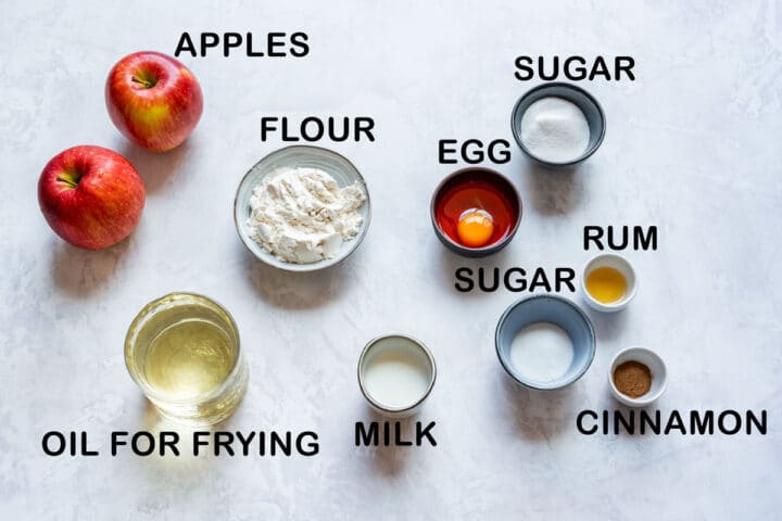 Ingredients for fried apple rings: apples, flour, egg, milk, sugar, rum, cinnamon and oil for frying.