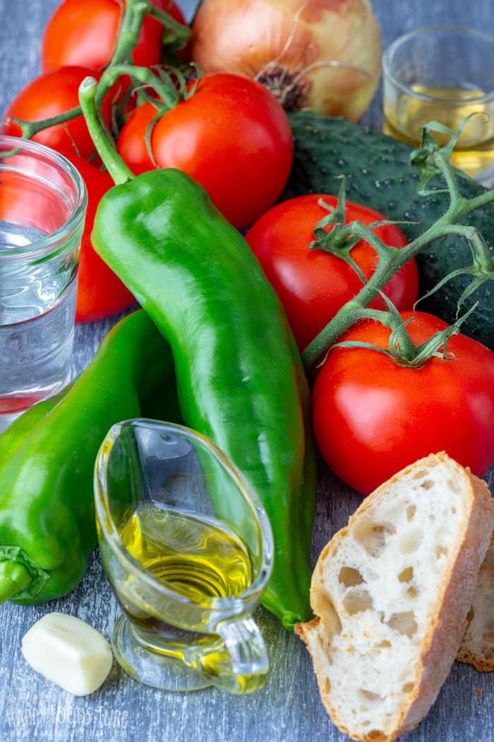 Ripe tomatoes, green Italian peppers, cucumber, onion, garlic, bread, olive oil, vinegar and water for making gazpacho.