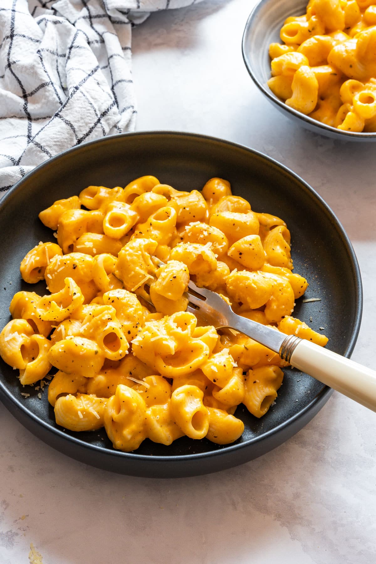 Creamy sweet potato mac and cheese topped with black pepper and a little grated cheddar.