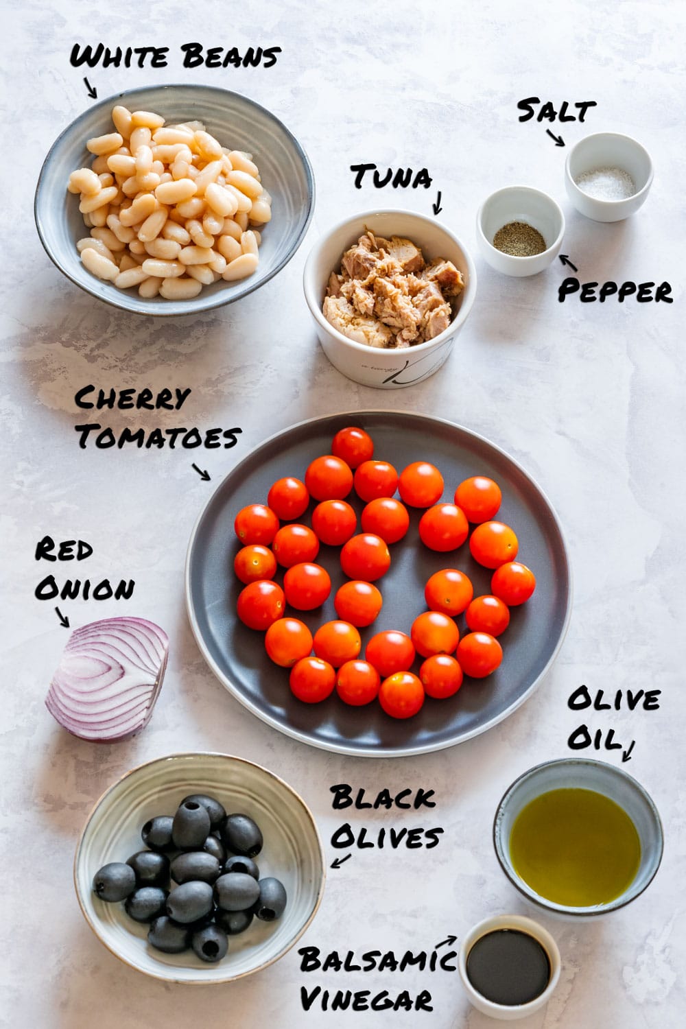 Labeled ingredients for tuna white bean salad: white beans, canned tuna, cherry tomatoes, red onion, black olives, olive oil, balsamic vinegar, salt and pepper.