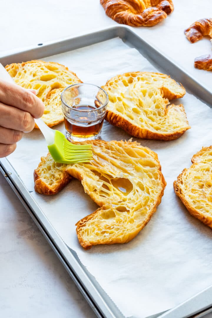Brushing the cut sides of croissants with maple syrup before adding the filling.