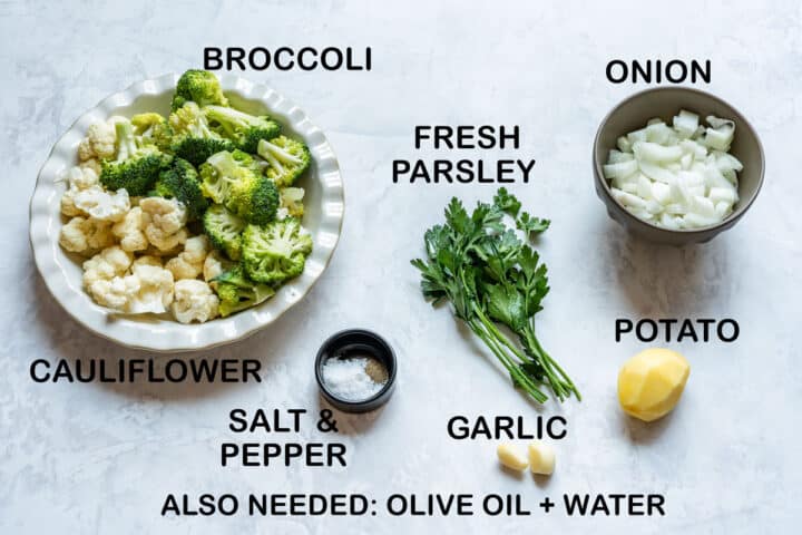 Ingredients for the soup: broccoli and cauliflower florets, diced onion, fresh parsley, a peeled potato, garlic, salt, pepper, olive oil and water.